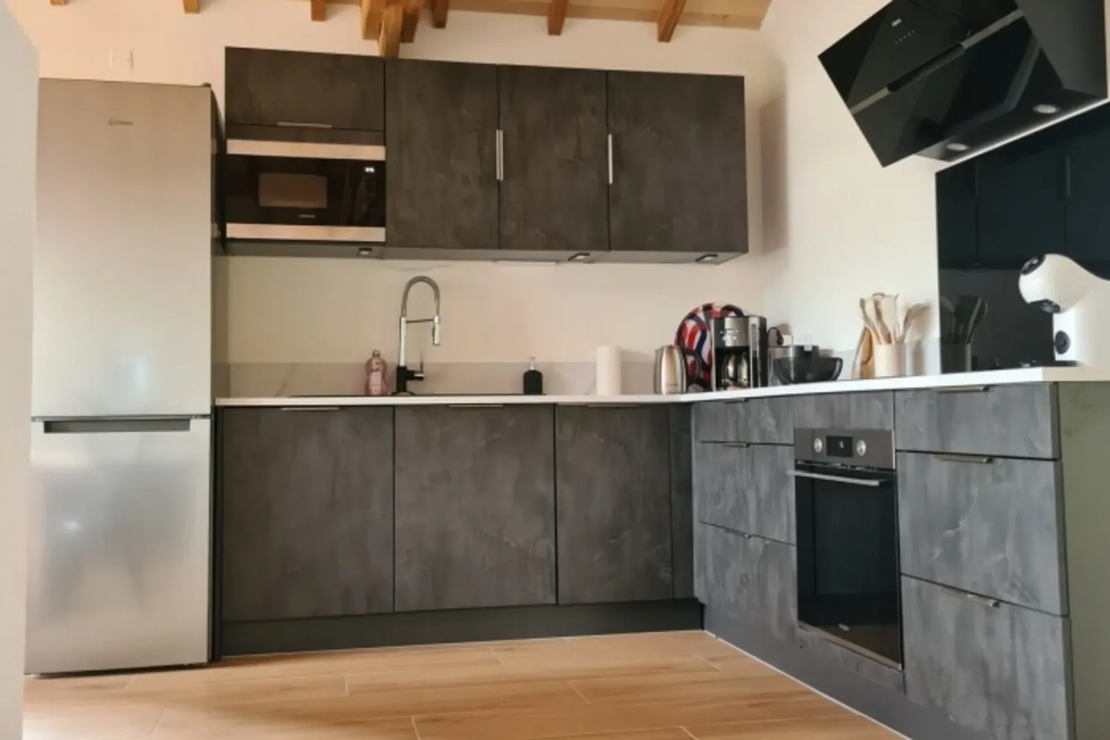 Fitted kitchen with slate-effect units, fridge, oven, microwave and coffee makers