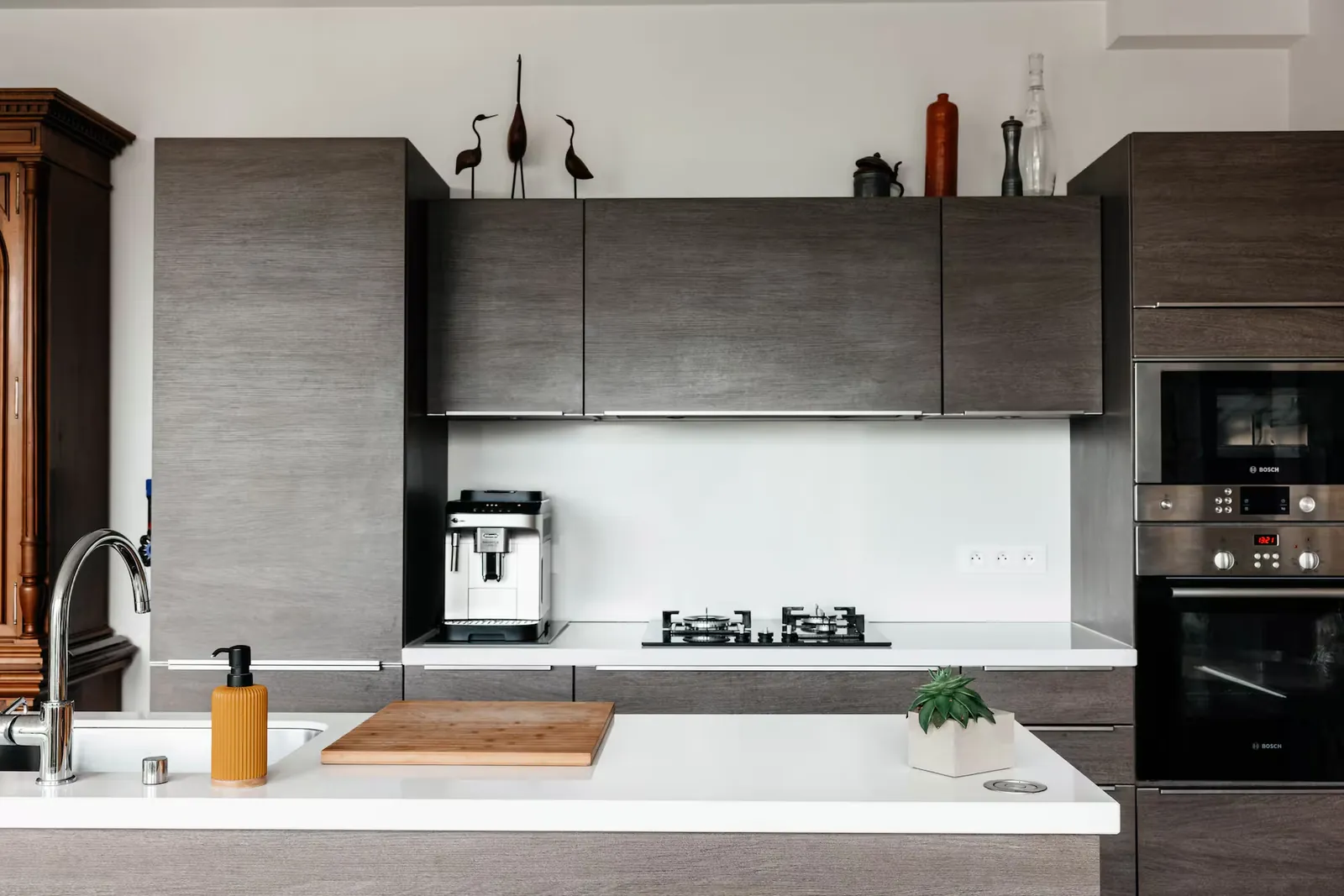 Cuisine équipée avec machine à expresso, plaque de cuisson et fours encastrés