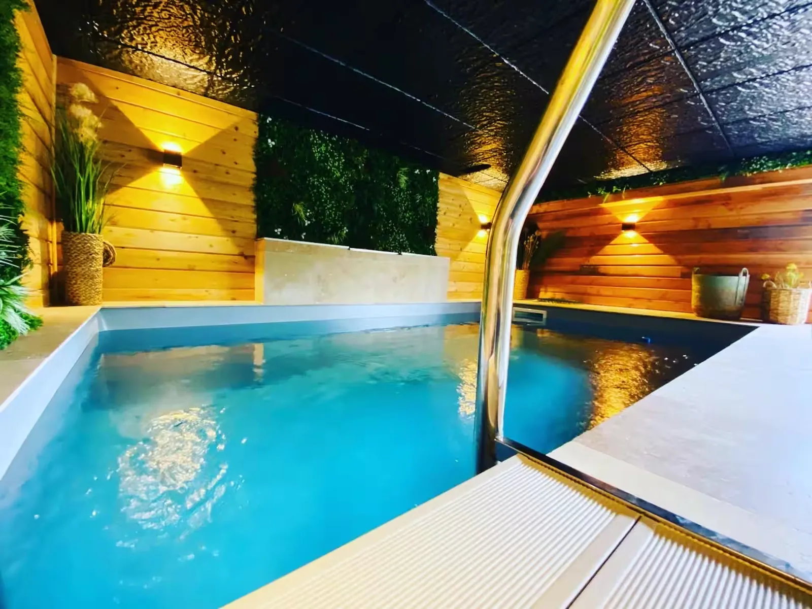 Piscine intérieure chauffée éclairée, habillée de bois, à La Motte Féodale