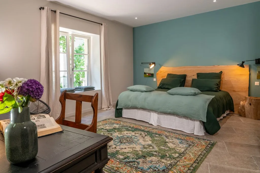 Green-toned bedroom with a double bed and a raw-wood headboard, Le Clos d'Abrigeon