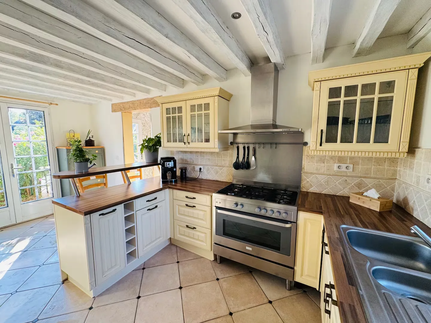 Cuisine équipée avec piano de cuisson inox, hotte et plan de travail en bois, Le Clos du Veneur