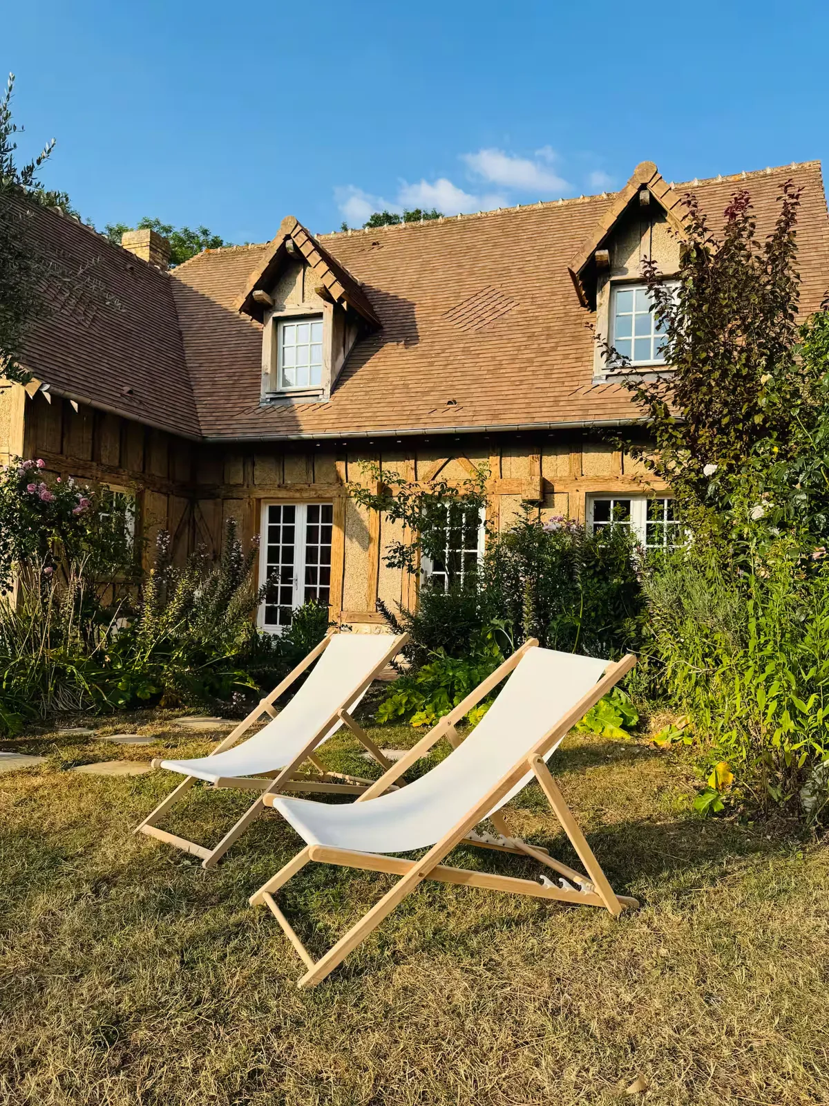 Deux transats en toile sur la pelouse du jardin, devant la maison, Le Clos du Veneur