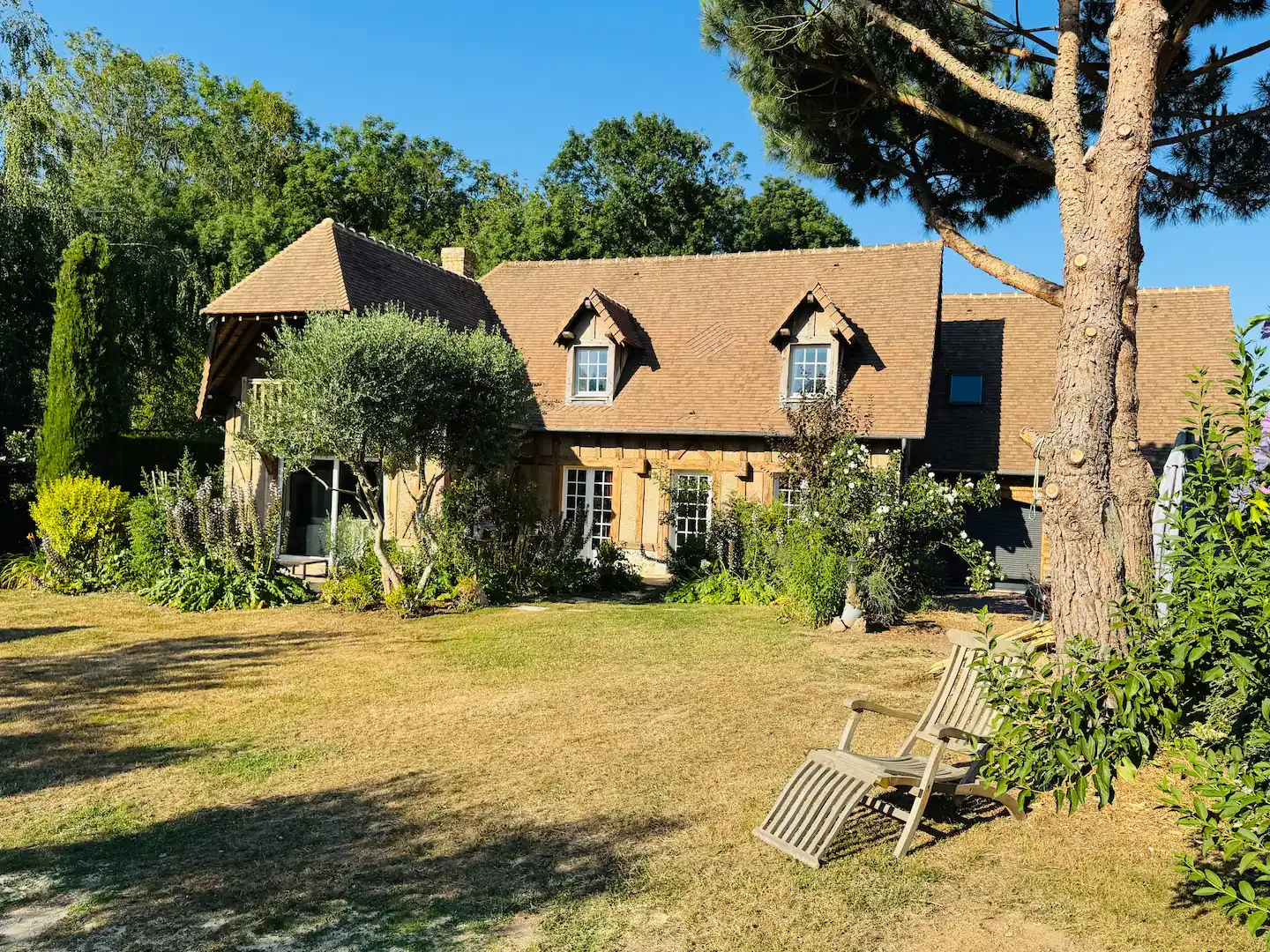 Maison normande à colombages et toit de tuiles, avec olivier, pin parasol et pelouse, Le Clos du Veneur