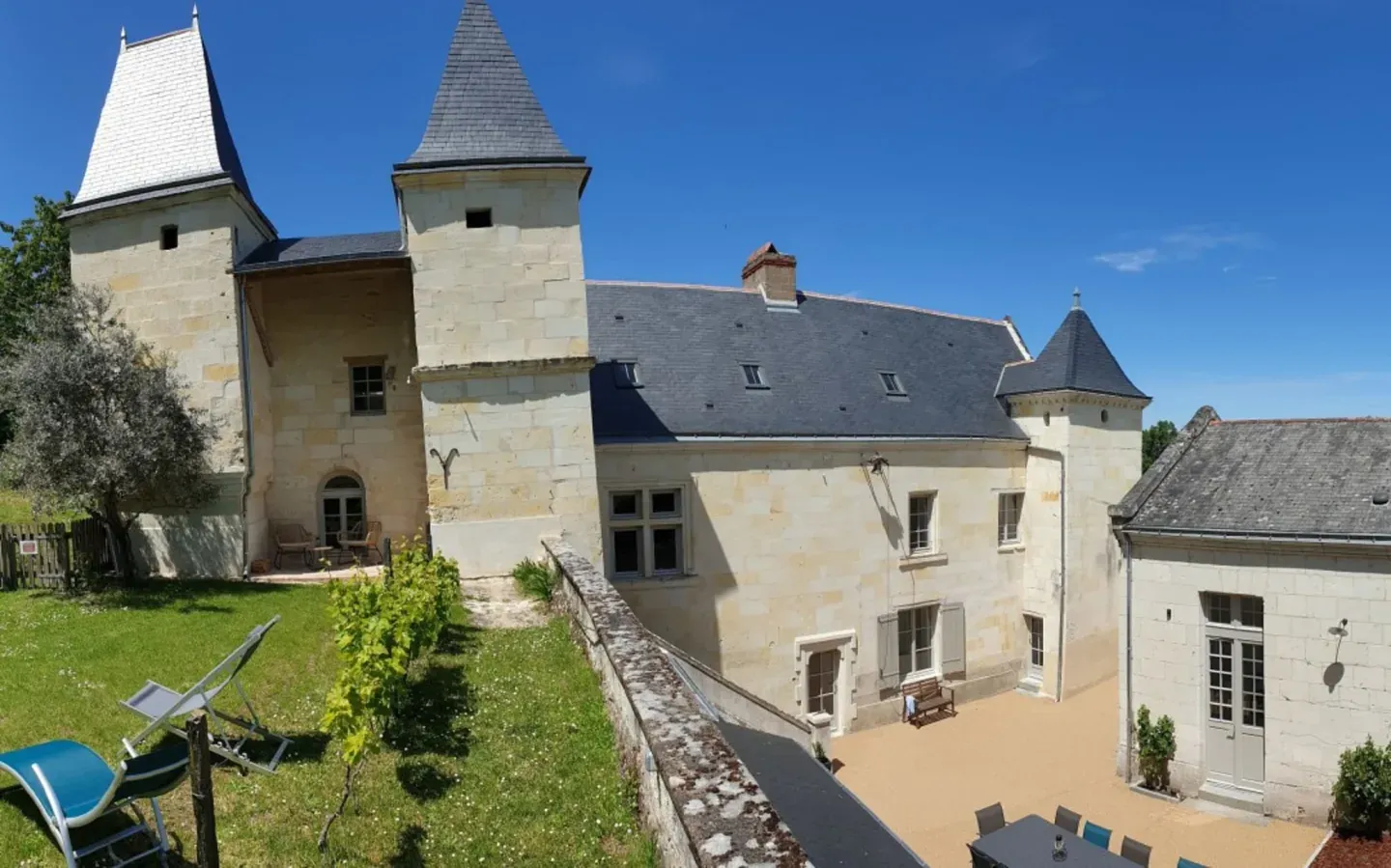 Tufa stone façade and slate-roofed turrets of Logis Escale, a 17th-century house in Cunault