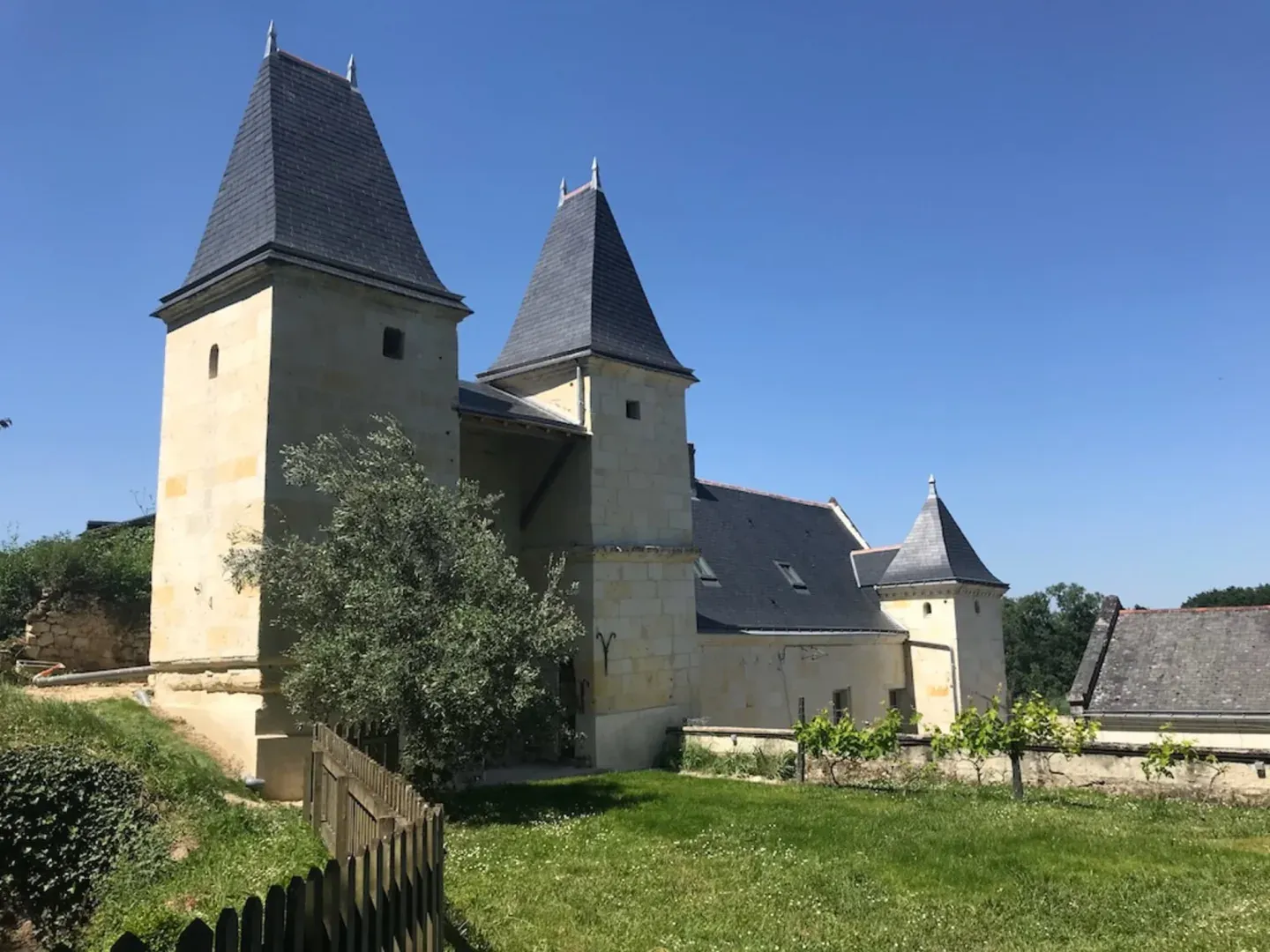 Slate-roofed tufa stone towers and garden of Logis Escale in Cunault