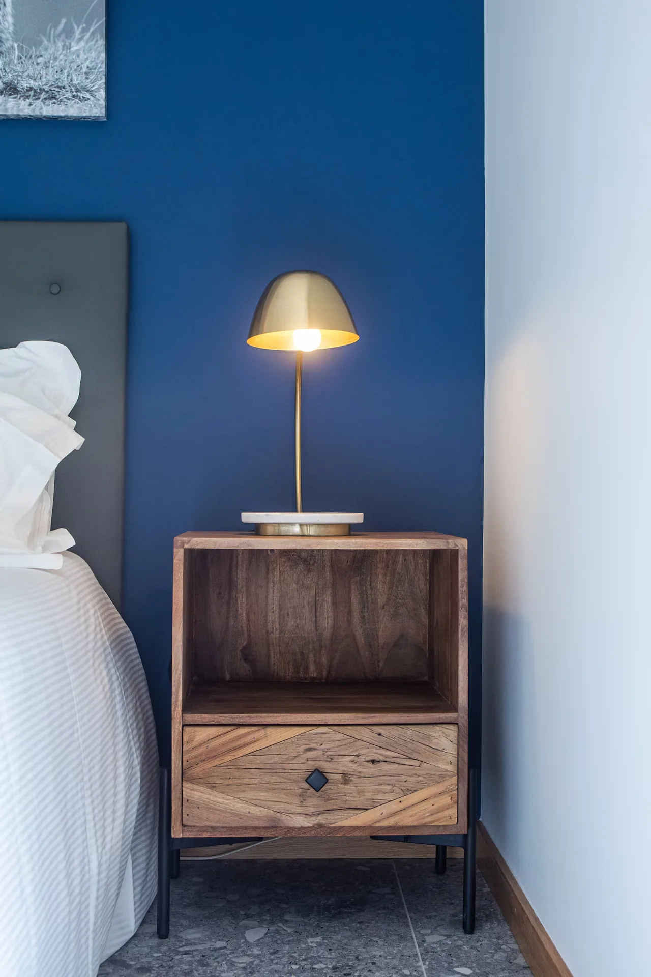 Wooden bedside table and brass lamp in the bedroom, Maison Chassel in Balazuc