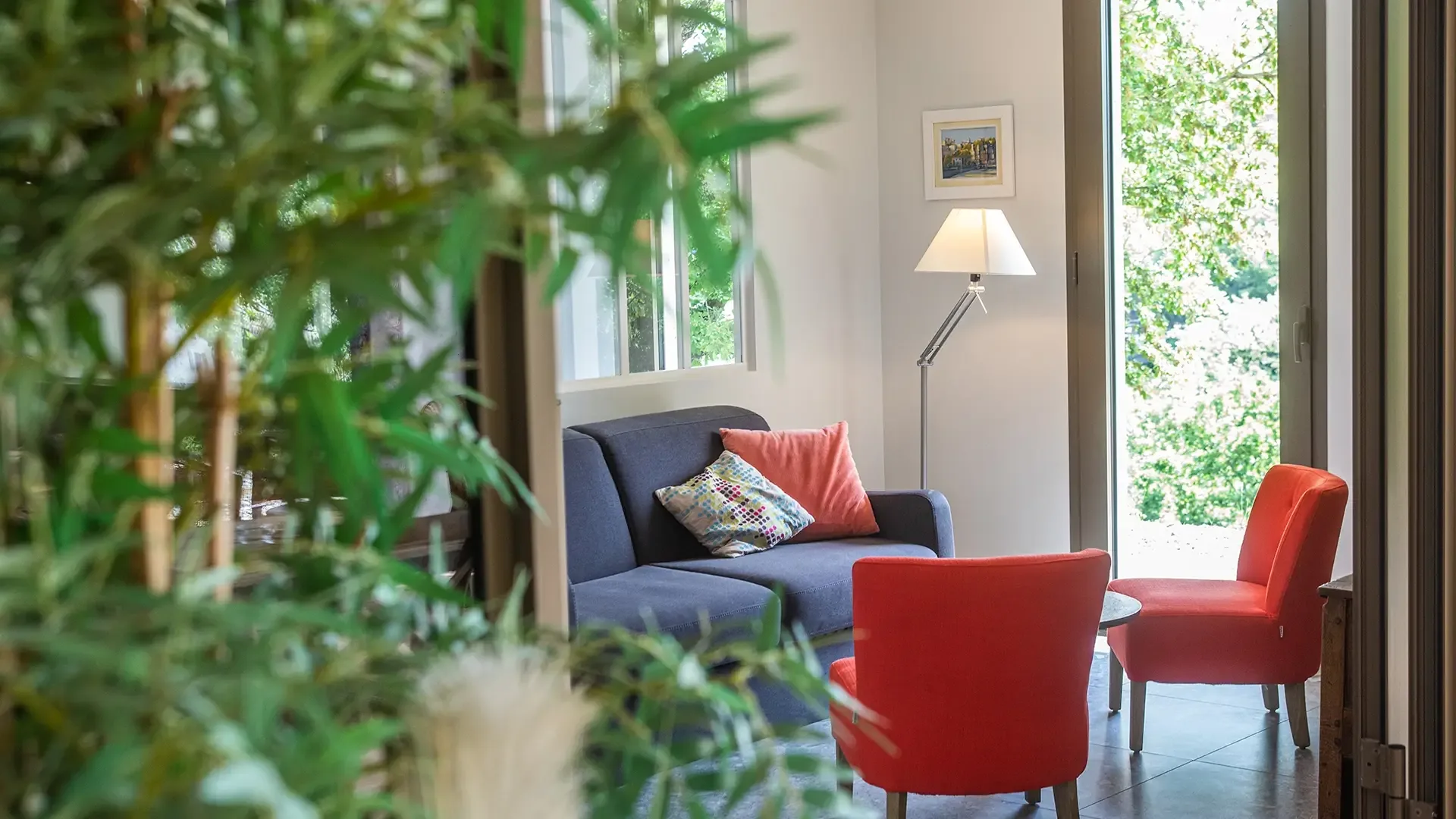 Sitting area with sofa, armchairs and French window onto the greenery, Maison Chassel gîte