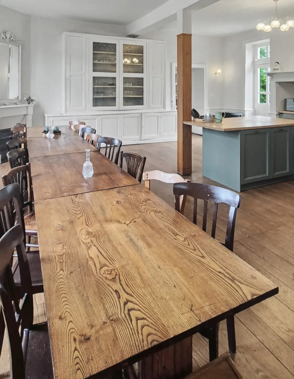 Salle à manger avec une grande table en bois pour douze convives