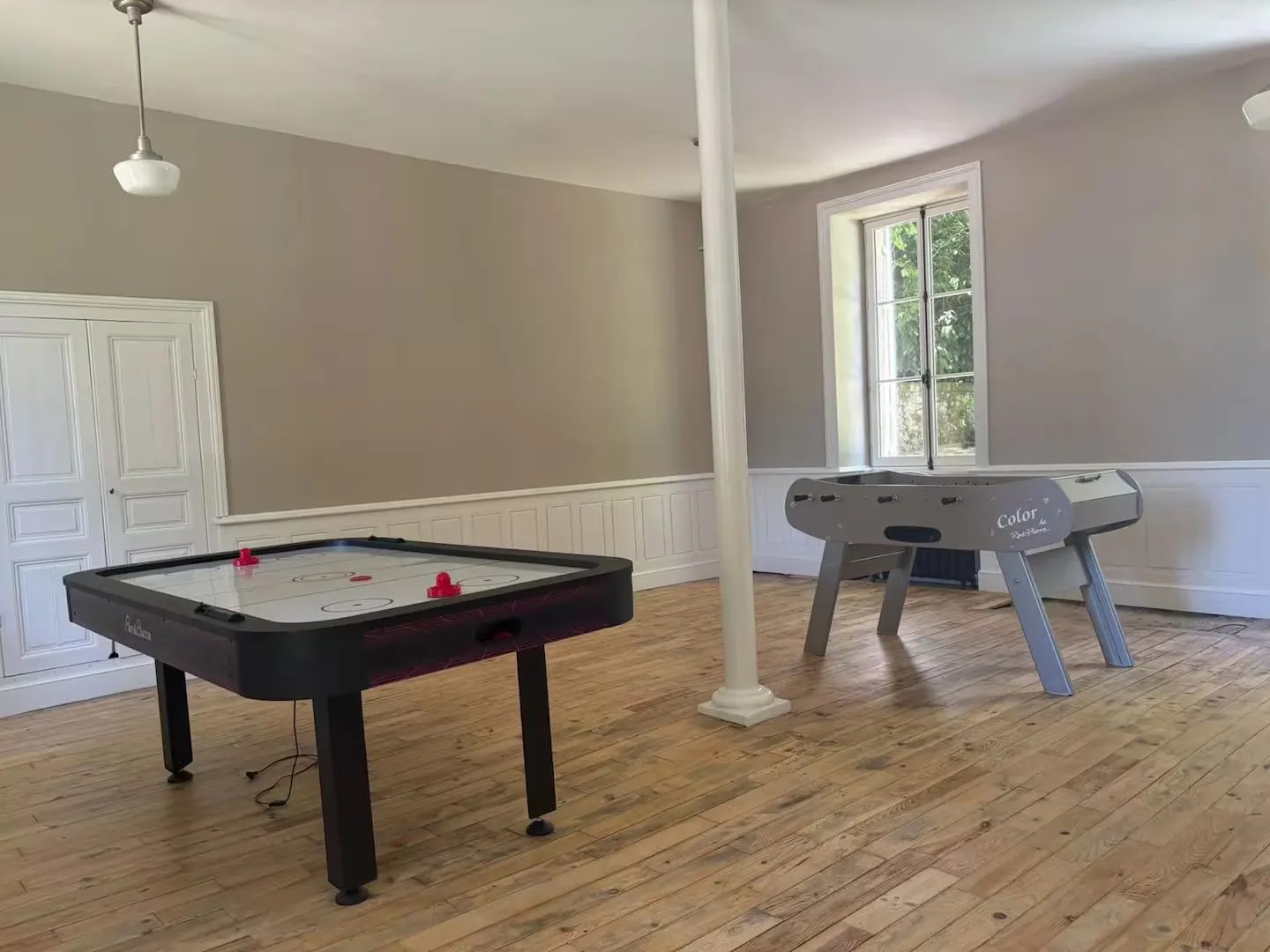 Salle de jeux avec baby-foot et table de air hockey