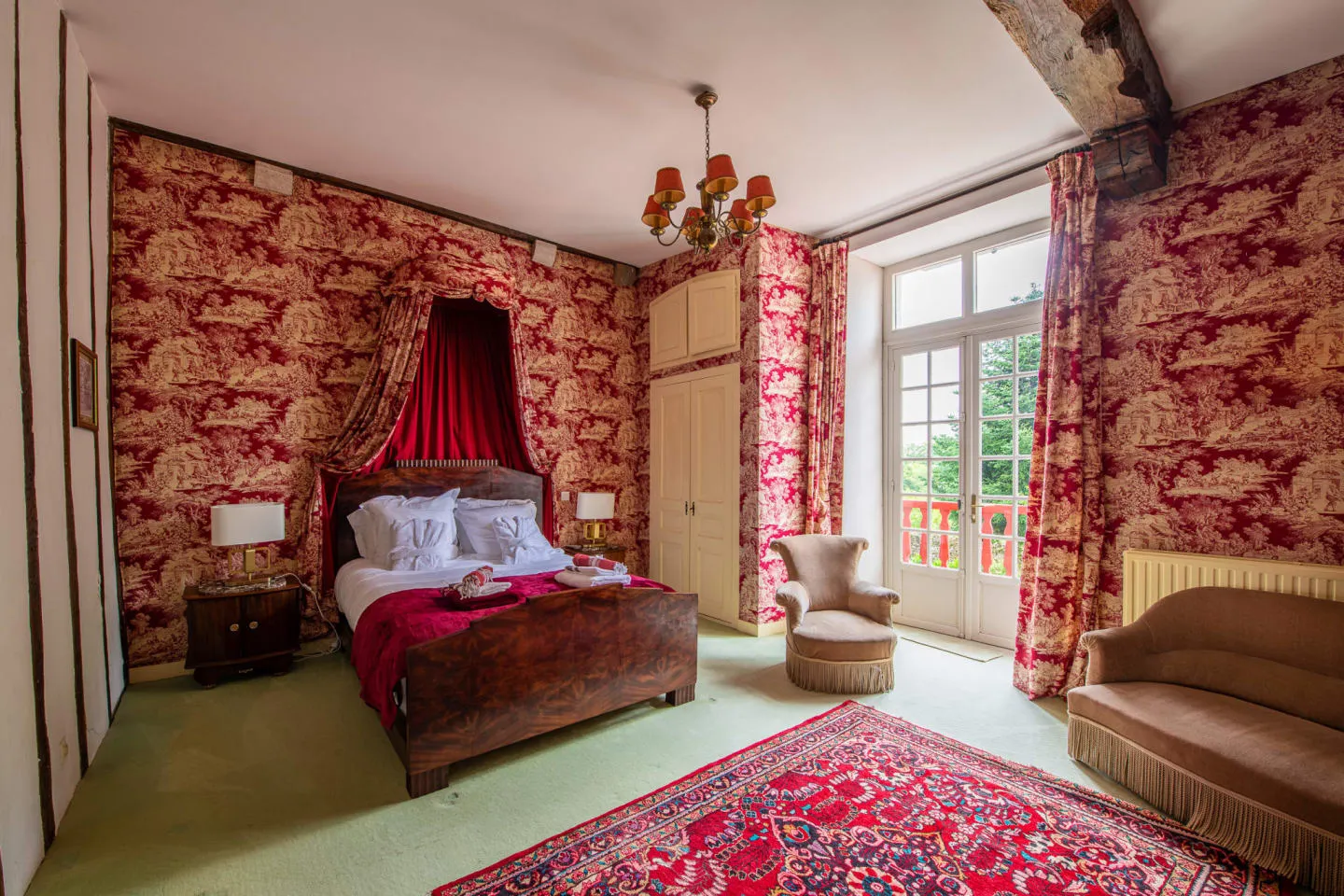 Chambre tendue de toile de Jouy rouge avec ciel de lit et balcon, Maison Luroa