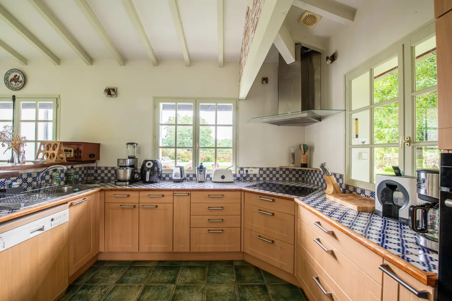 Cuisine équipée aux carreaux bleus et blancs ouvrant sur le jardin, Maison Luroa