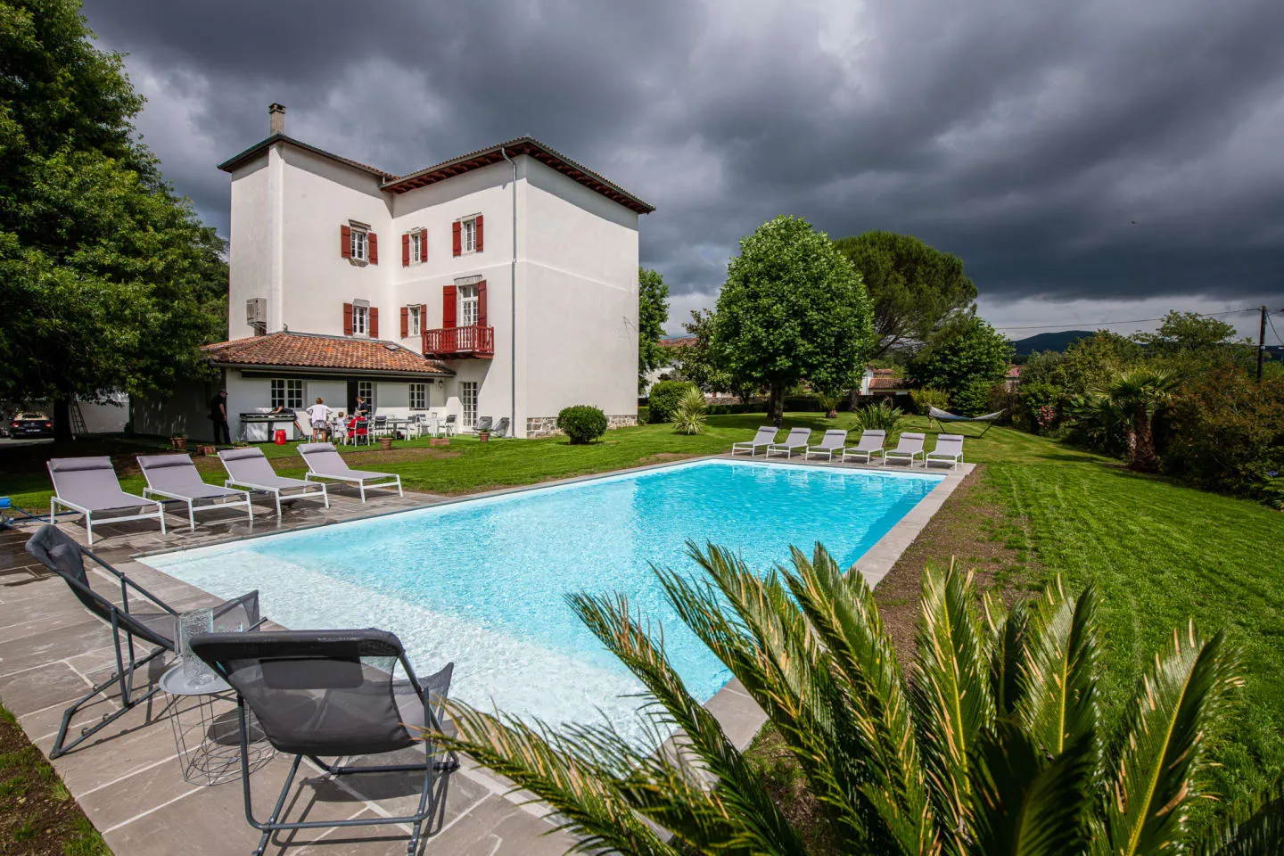 Piscine chauffée et transats devant la Maison Luroa, maison noble basque à Cambo-les-Bains